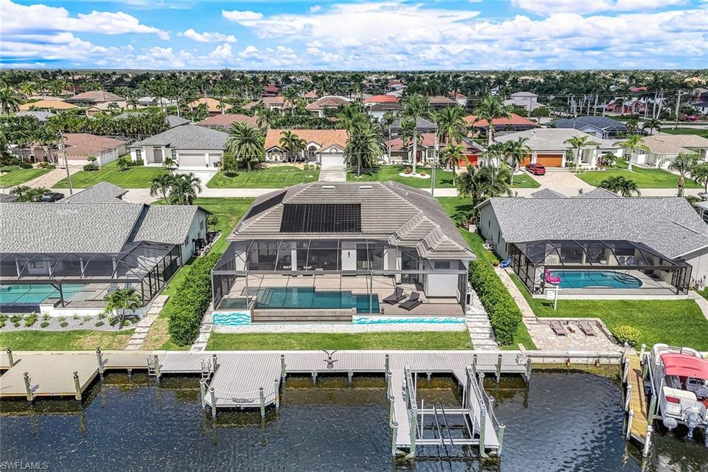 Aerial perspective of suburban area with a pool and a large body of water