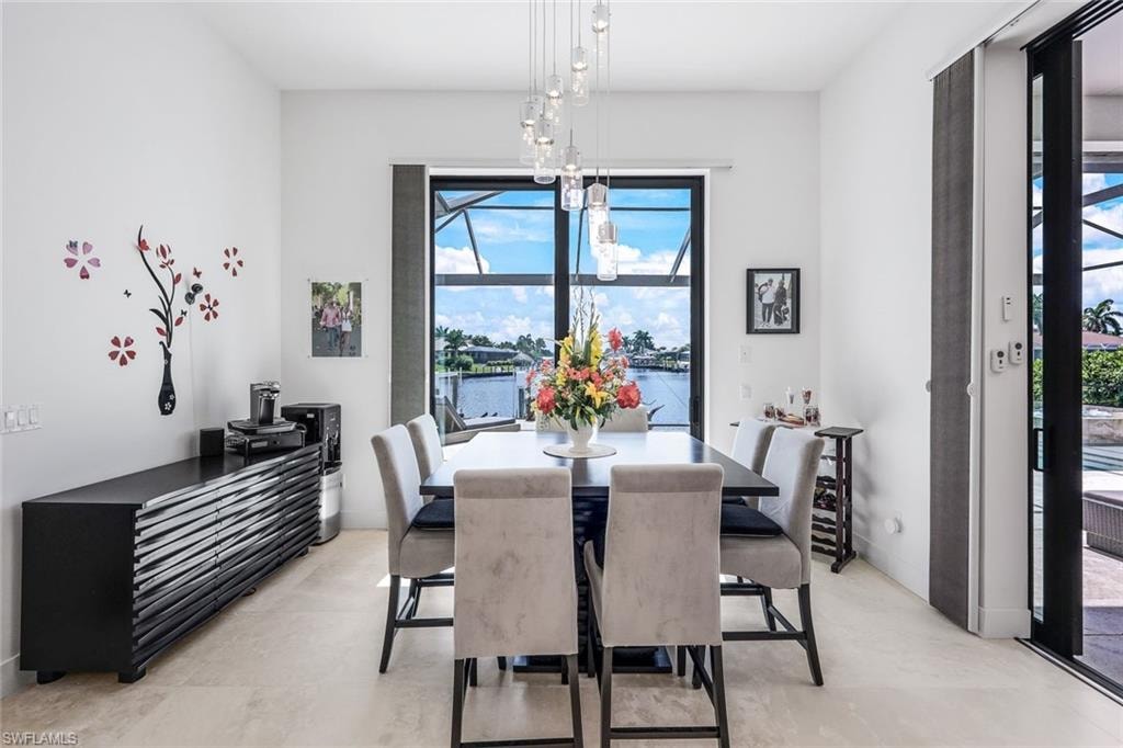 Dining space with a water view, plenty of natural light, and a chandelier
