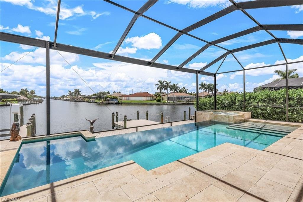 View of pool with a sunroom, a water view, a pool with connected hot tub, a lanai, and a patio area