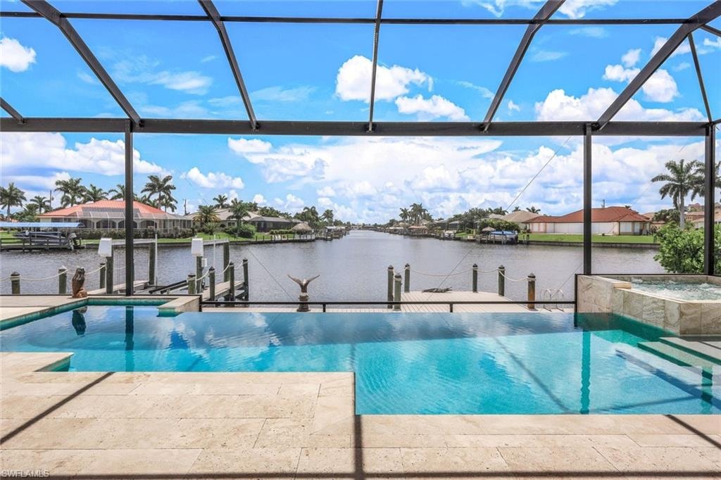 View of pool featuring a water view, a boat dock, and a lanai