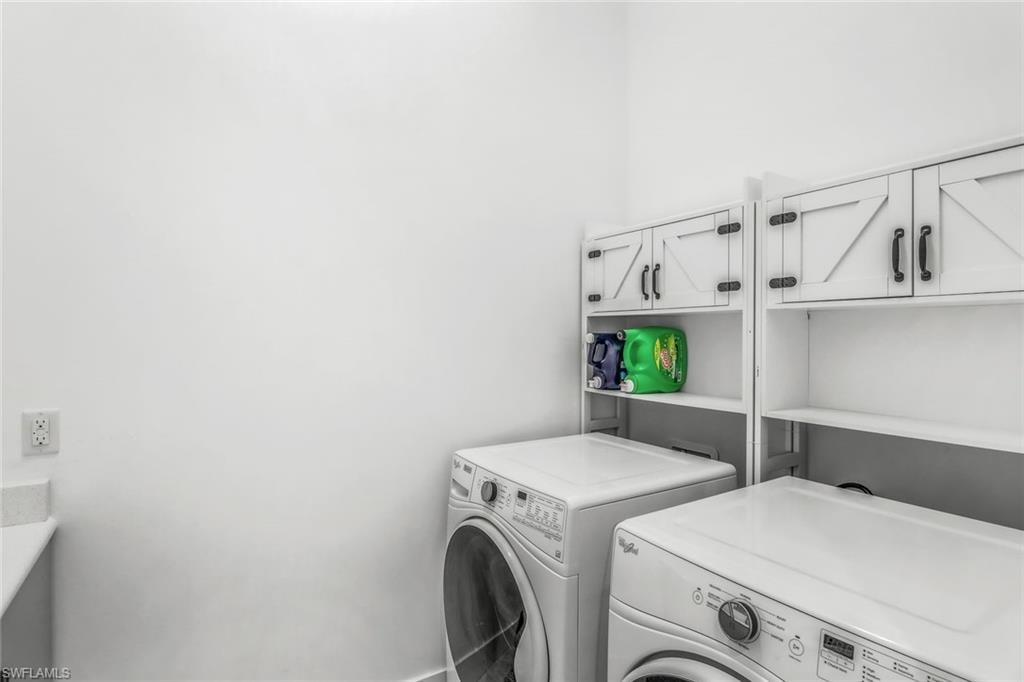Washroom with cabinet space and washing machine and clothes dryer