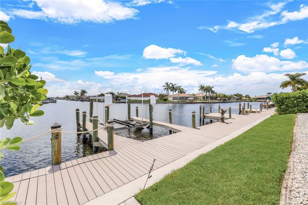 Dock featuring a water view, boat lift, and a yard