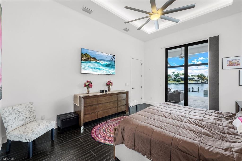 Bedroom with access to exterior, a ceiling fan, and wood finished floors