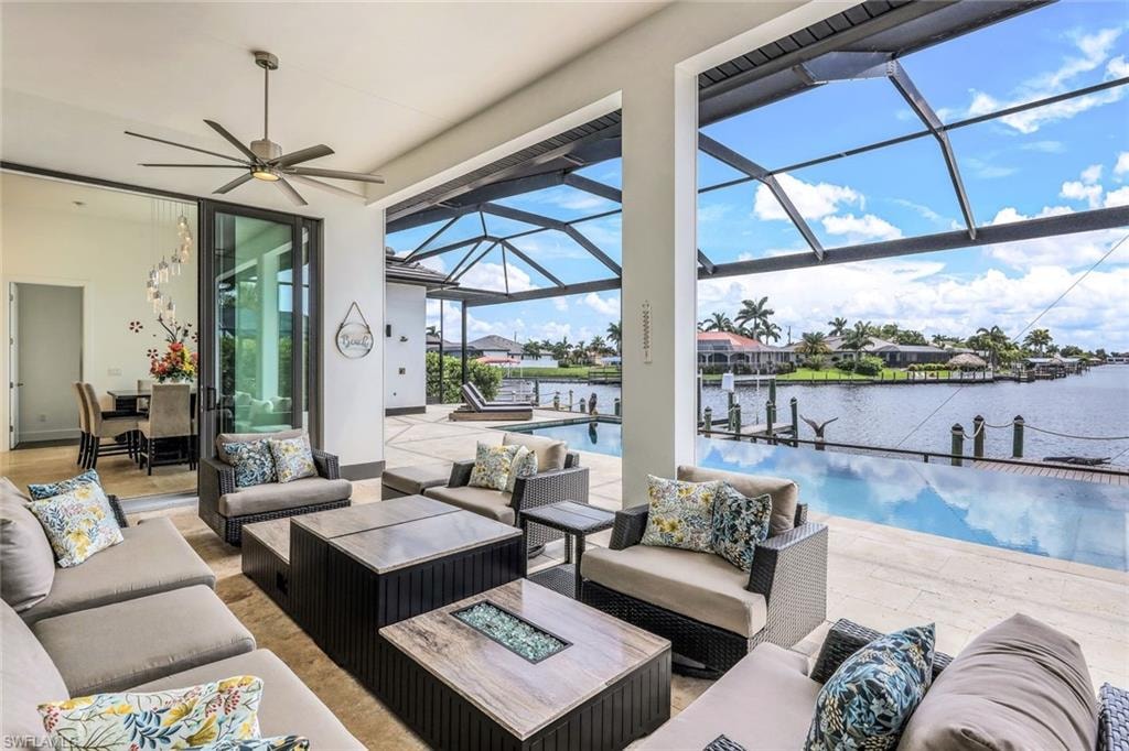 View of patio / terrace featuring outdoor lounge area, a sunroom, a lanai, a water view, and a ceiling fan
