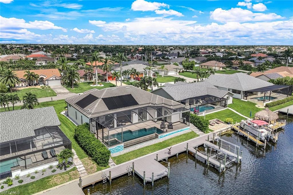 Aerial perspective of suburban area with a large body of water and a pool
