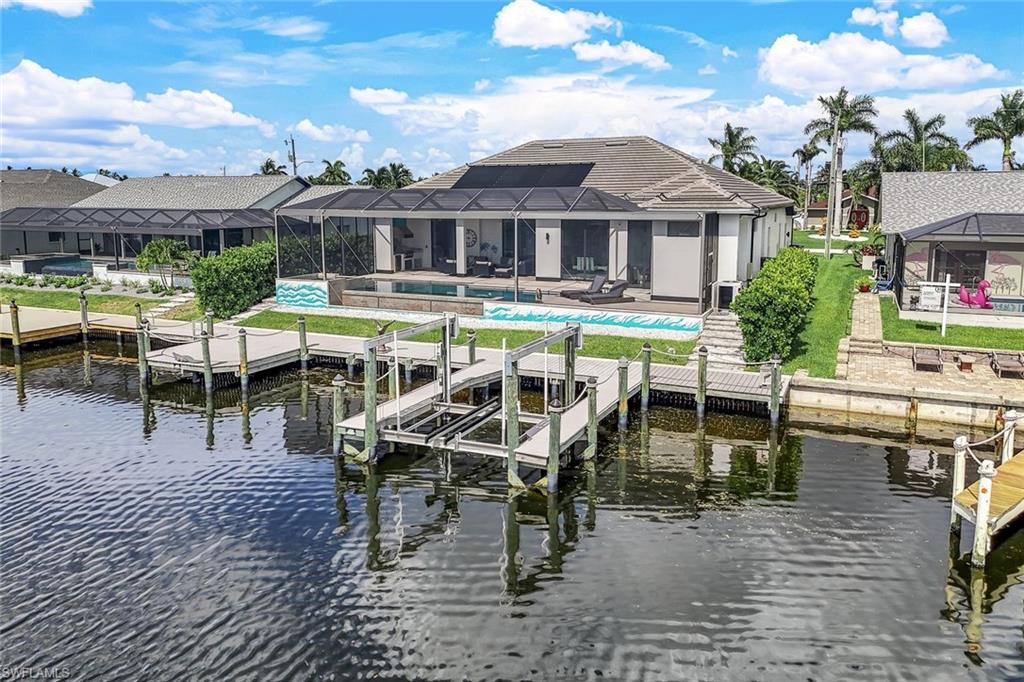 Dock with boat lift, glass enclosure, and a sunroom