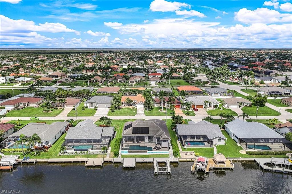 Aerial view of residential area featuring a nearby body of water