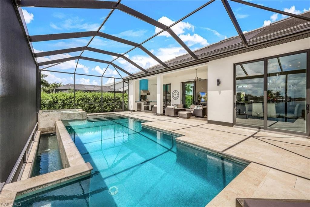 View of pool featuring ceiling fan, a sunroom, a patio area, a lanai, and an outdoor hangout area