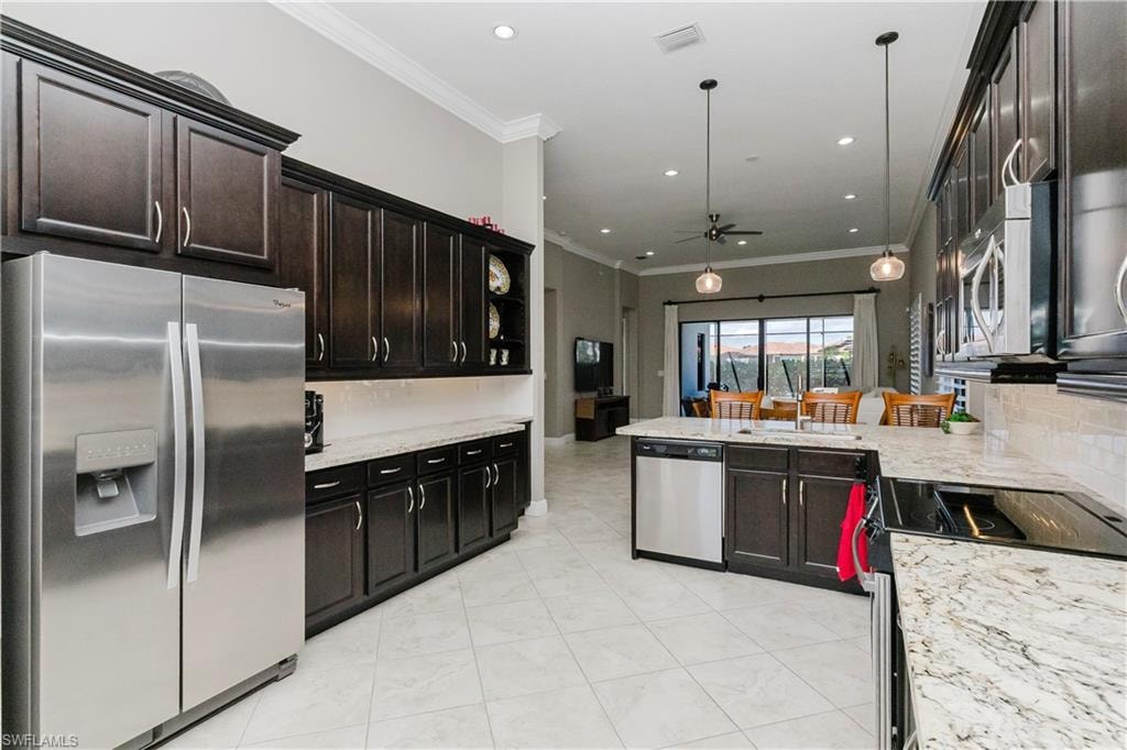 Kitchen featuring stainless steel appliances, tasteful backsplash, ornamental molding, a ceiling fan, and light stone counters