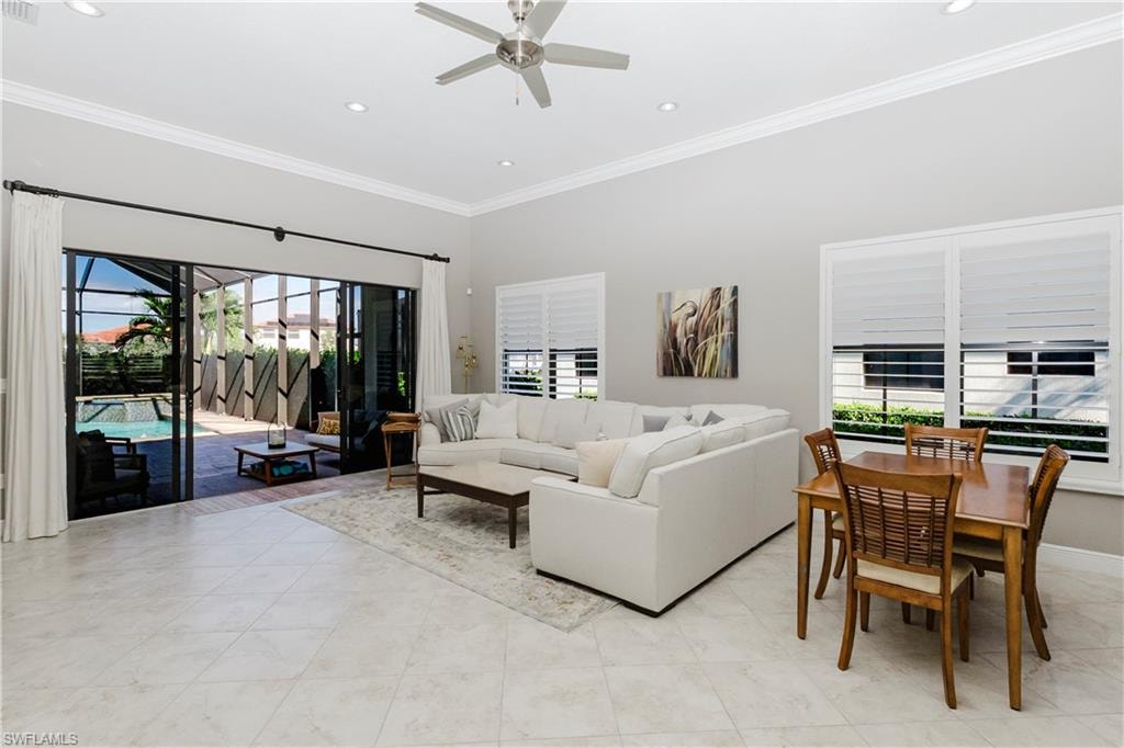 Living room with ornamental molding, a sunroom, recessed lighting, ceiling fan, and light tile patterned floors