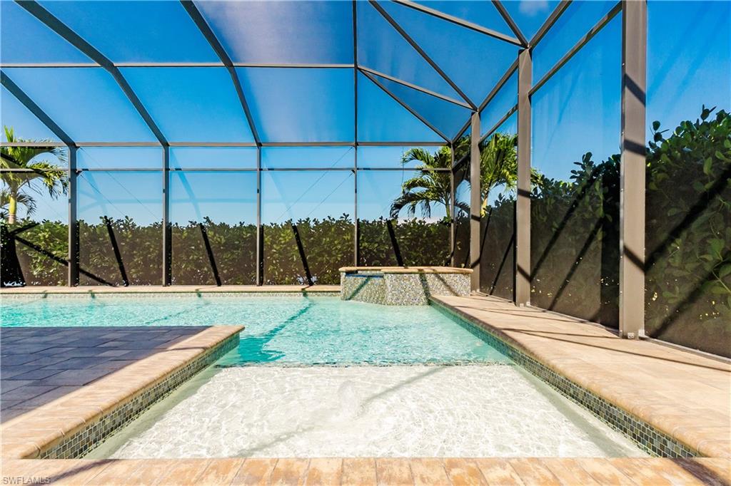 View of swimming pool with a lanai and a pool with connected hot tub