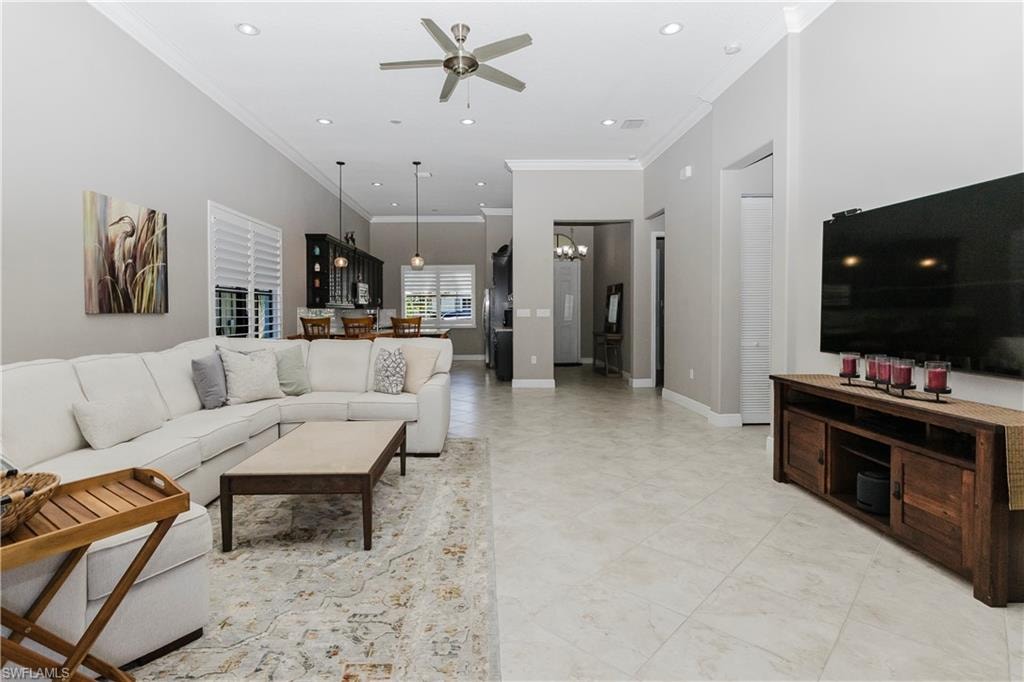 Living area featuring crown molding, a ceiling fan, recessed lighting, and a chandelier