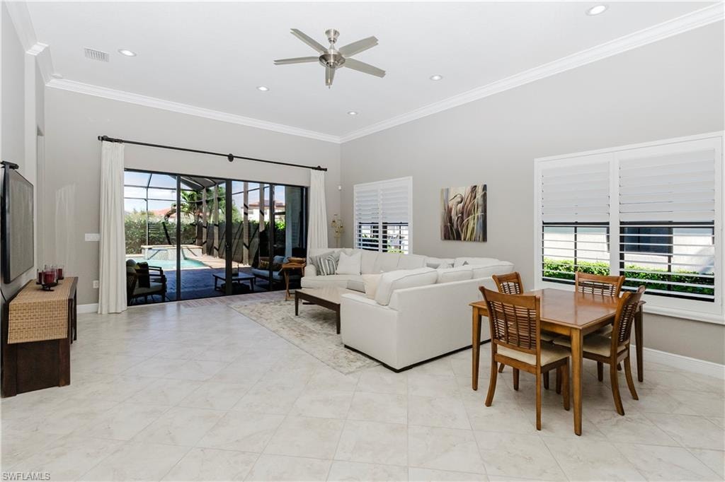 Living room featuring a sunroom, crown molding, ceiling fan, recessed lighting, and light tile patterned floors