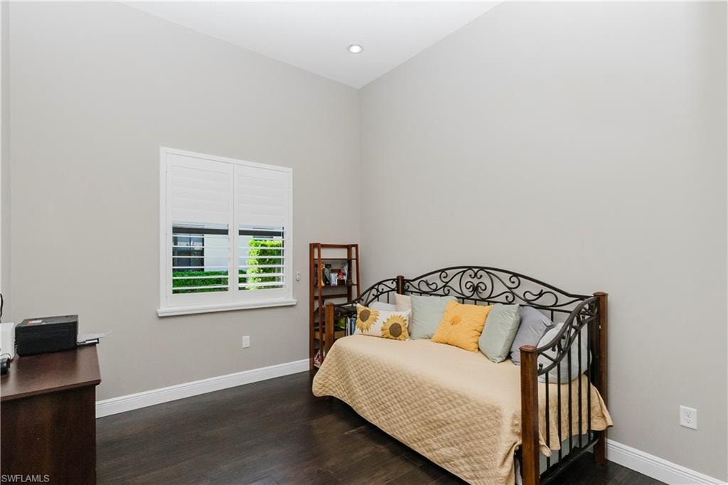 Bedroom with dark wood-style floors and recessed lighting