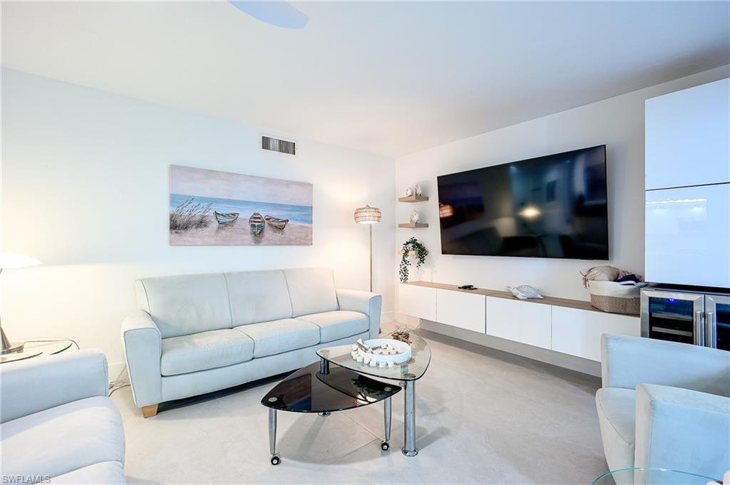 Living area featuring wine cooler and concrete floors