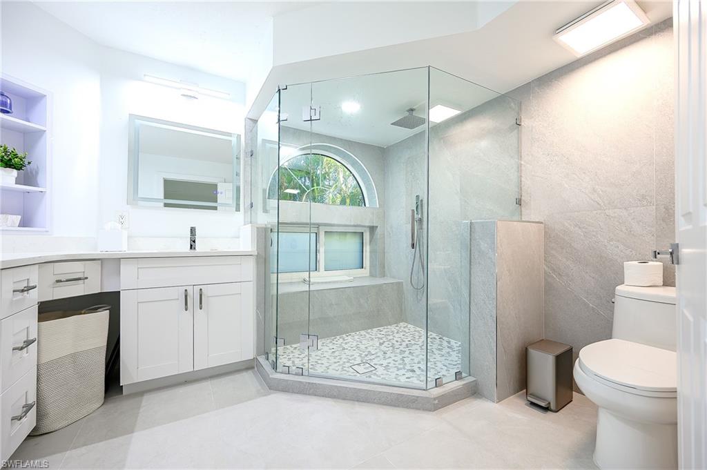 Full bathroom featuring vanity, a stall shower, and light tile patterned floors