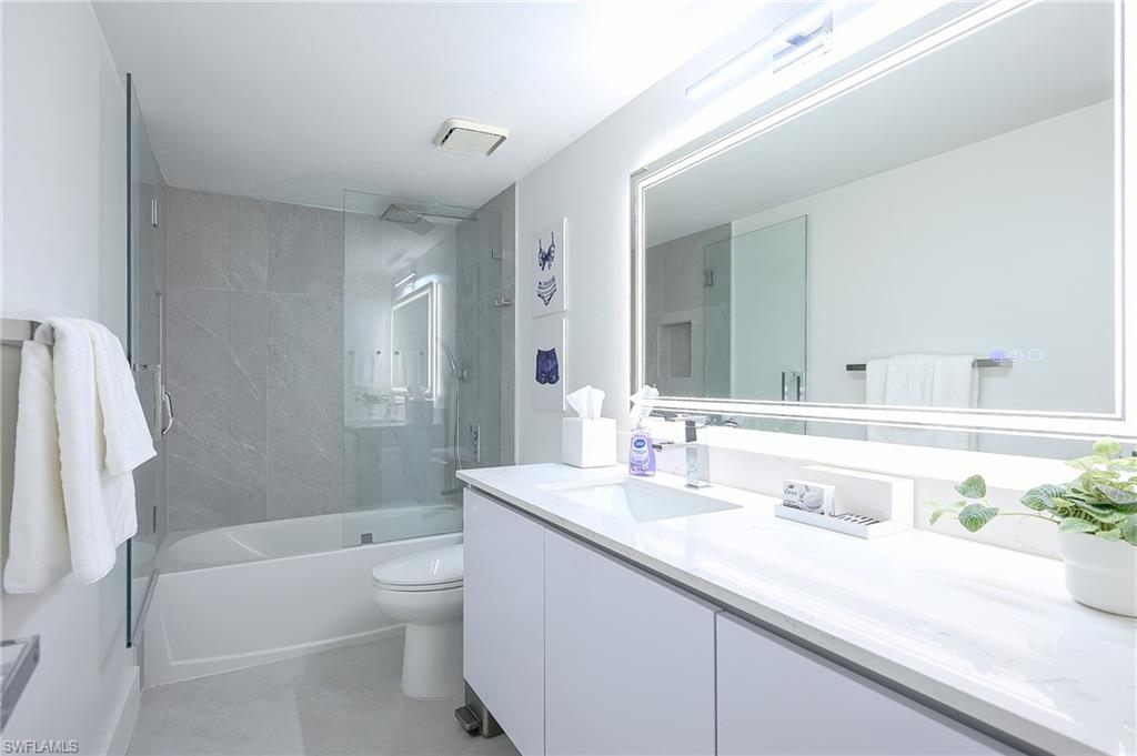 Bathroom with vanity and enclosed tub / shower combo