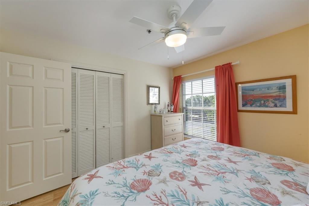 Bedroom with a ceiling fan, light wood-style floors, and a closet
