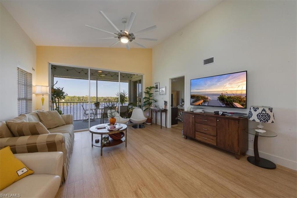 Living area with light wood-style flooring, high vaulted ceiling, and ceiling fan