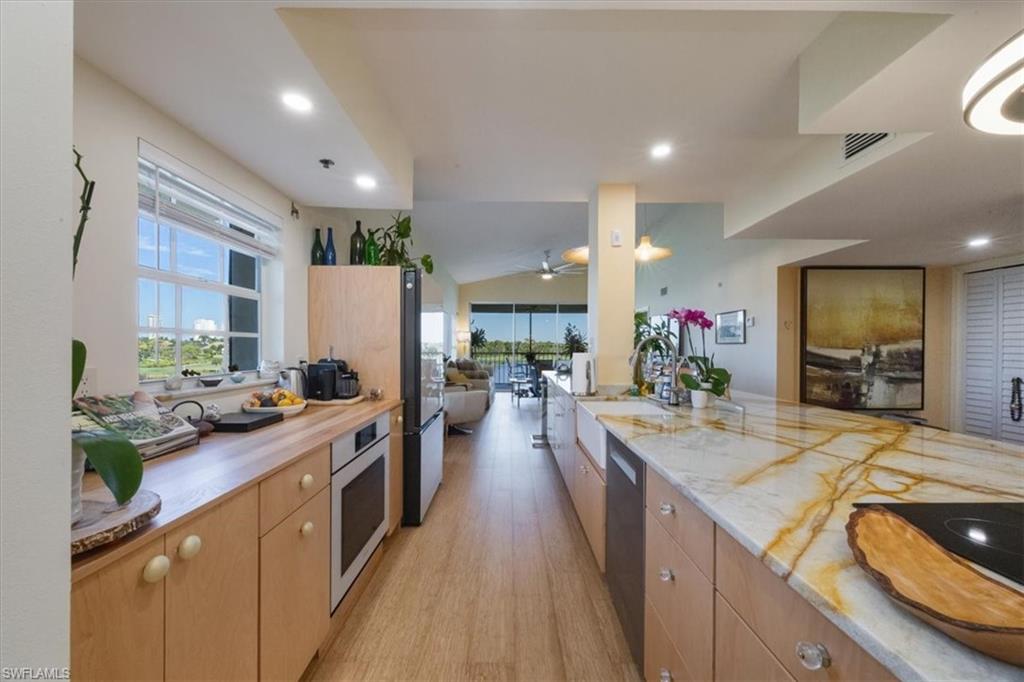 Kitchen featuring light wood-style flooring, open floor plan, plenty of natural light, light brown cabinets, and recessed lighting