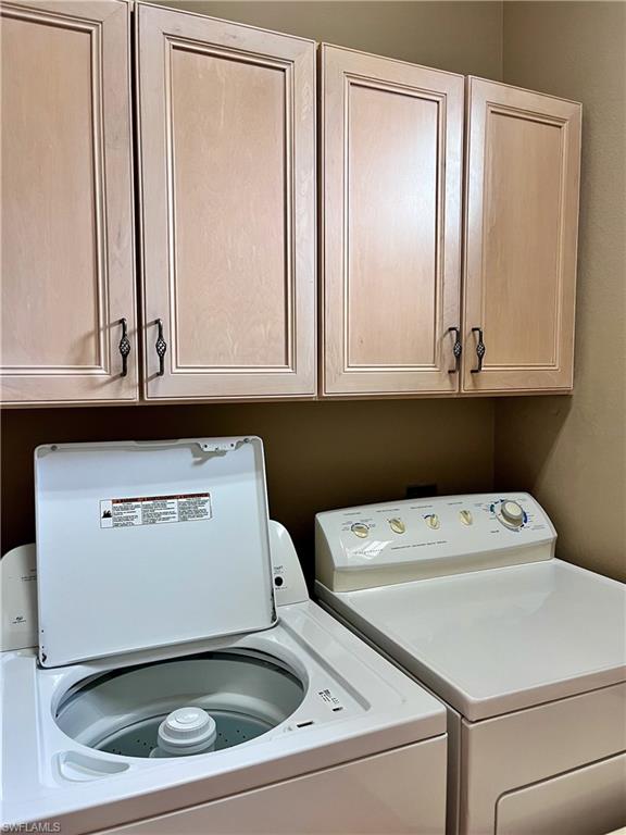 Washroom featuring washing machine and dryer and cabinet space