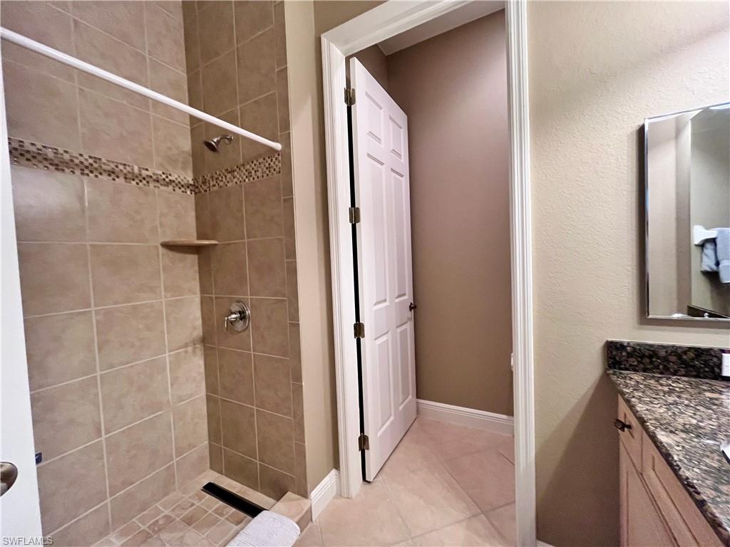 Bathroom featuring vanity, a stall shower, and light tile patterned floors