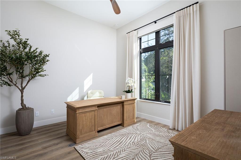 Office area with wood finished floors and ceiling fan