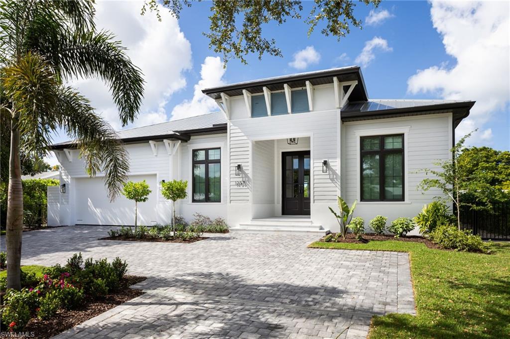 View of front of house featuring a metal roof, an attached garage, and decorative driveway