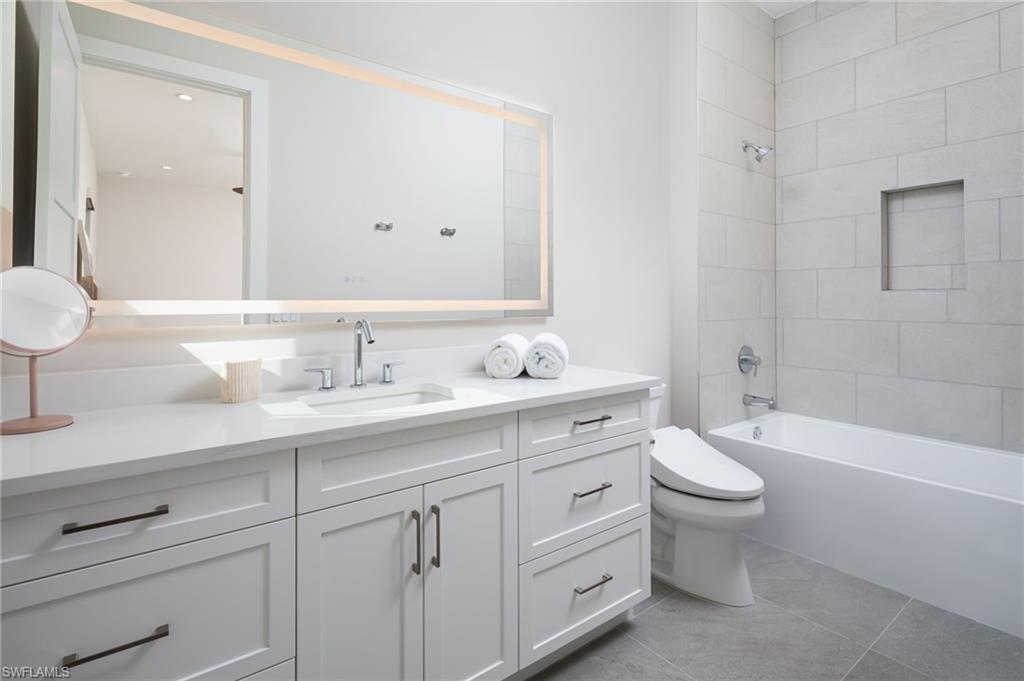 Full bath featuring vanity, shower / washtub combination, and light tile patterned floors