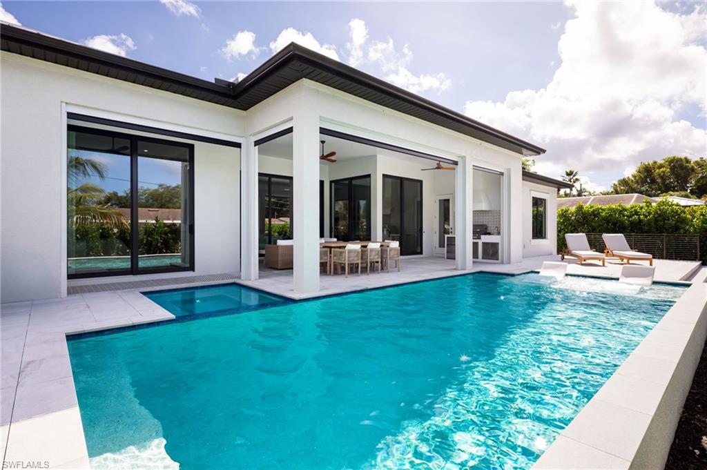 View of swimming pool with a ceiling fan, a patio, outdoor dining area, and a pool with connected hot tub