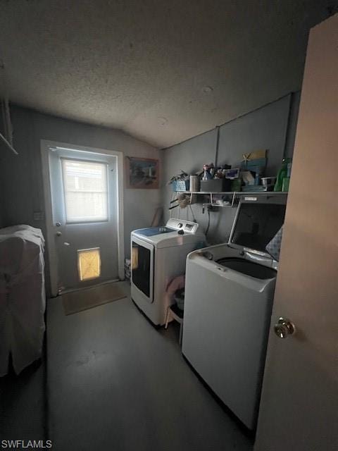 Laundry room featuring separate washer and dryer, lofted ceiling, a textured ceiling, and finished concrete flooring