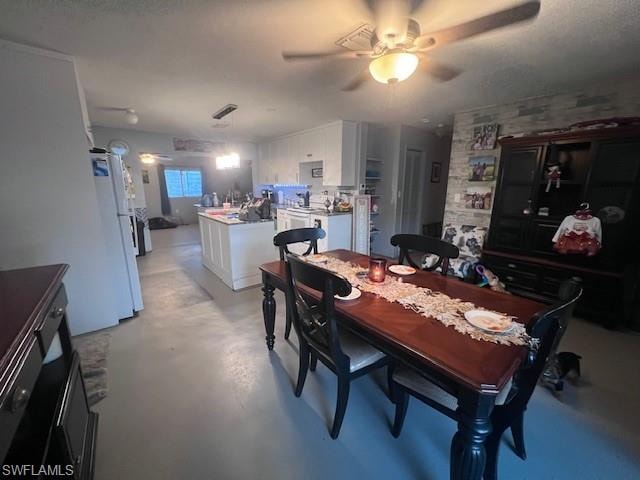 Dining area with concrete floors, ceiling fan, and a textured ceiling