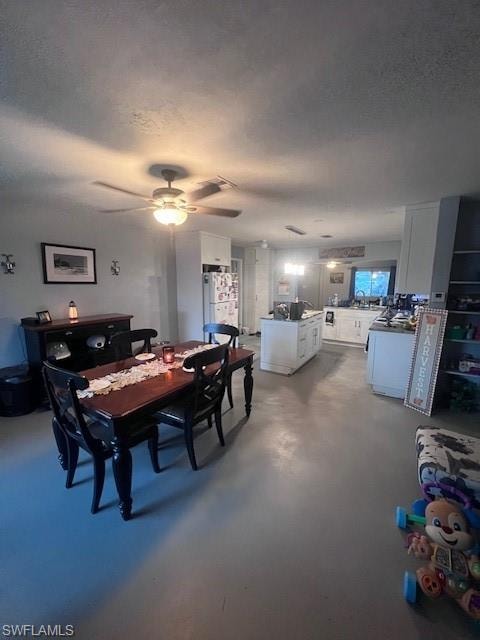 Dining space featuring a textured ceiling and finished concrete flooring