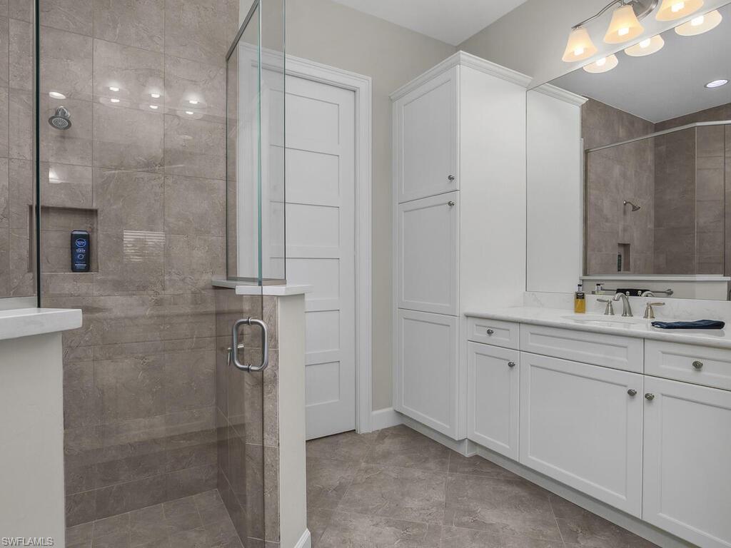 Master bath with dual vanities, quartz counter tops, frameless shower doors, walk in closet.