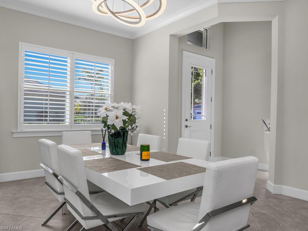Dining room featuring crown molding and a modern light fixture, plantation shutters.