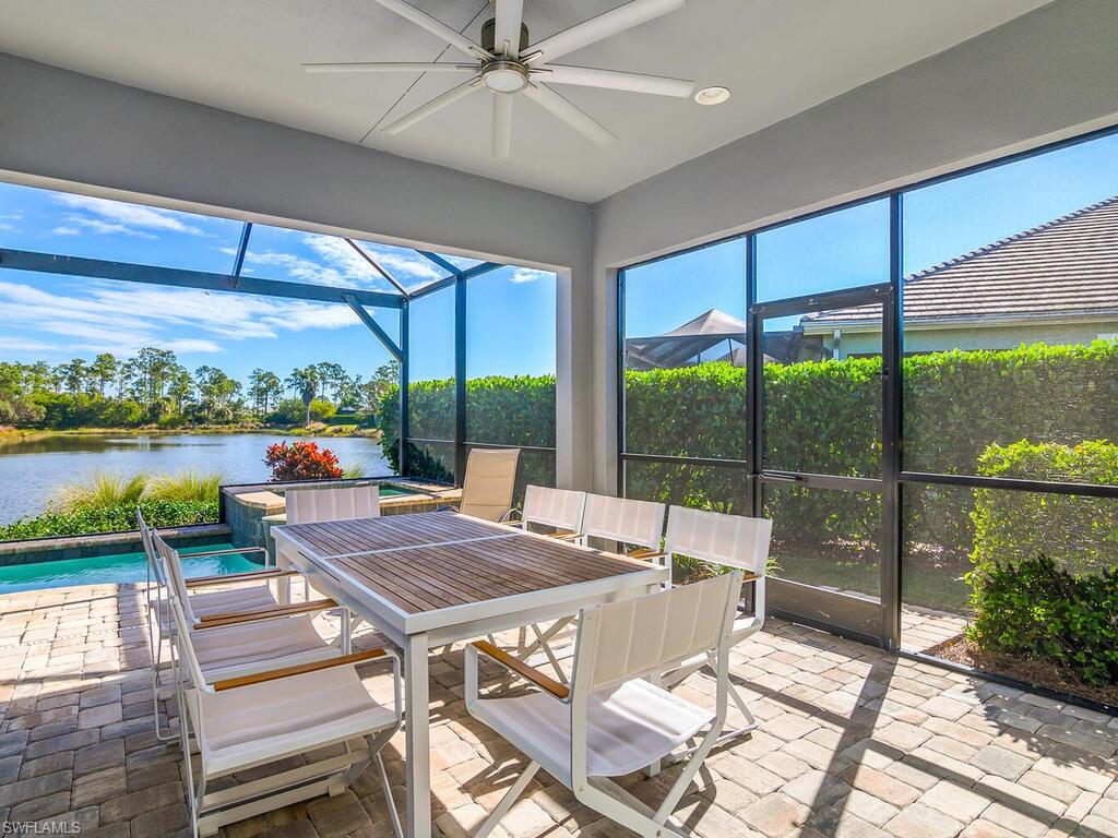 Sunroom / solarium with ceiling fan, outdoor dining area, a water view, and a patio