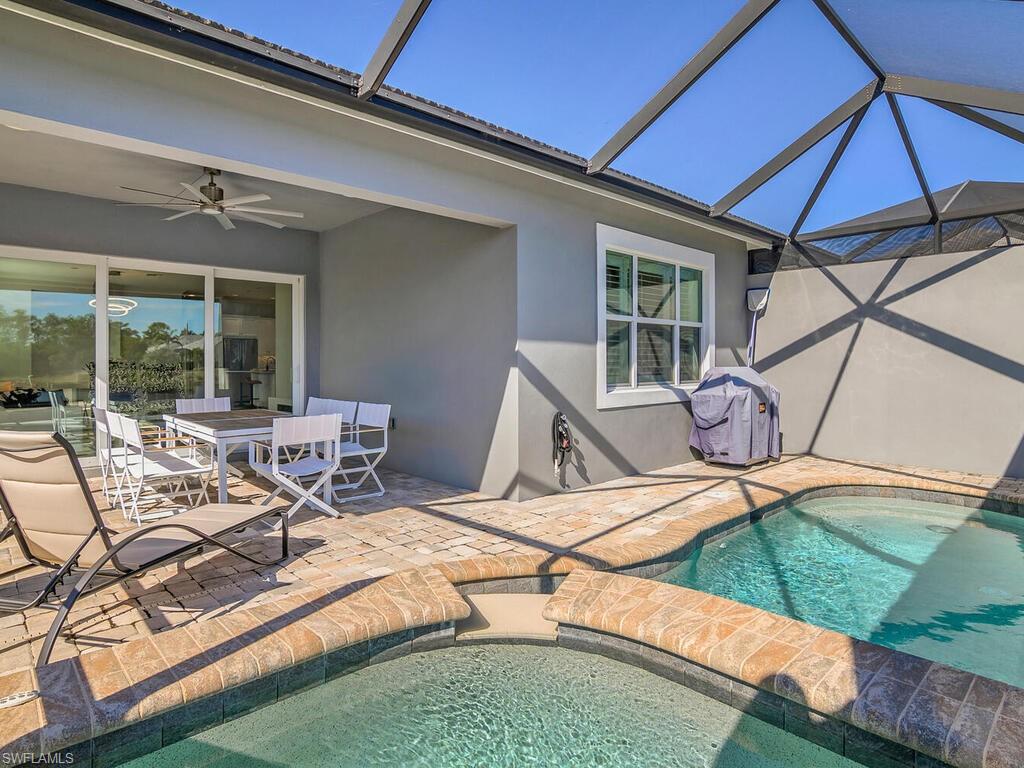 View of pool with a patio, a sunroom, a lanai, outdoor dining space, and ceiling fan