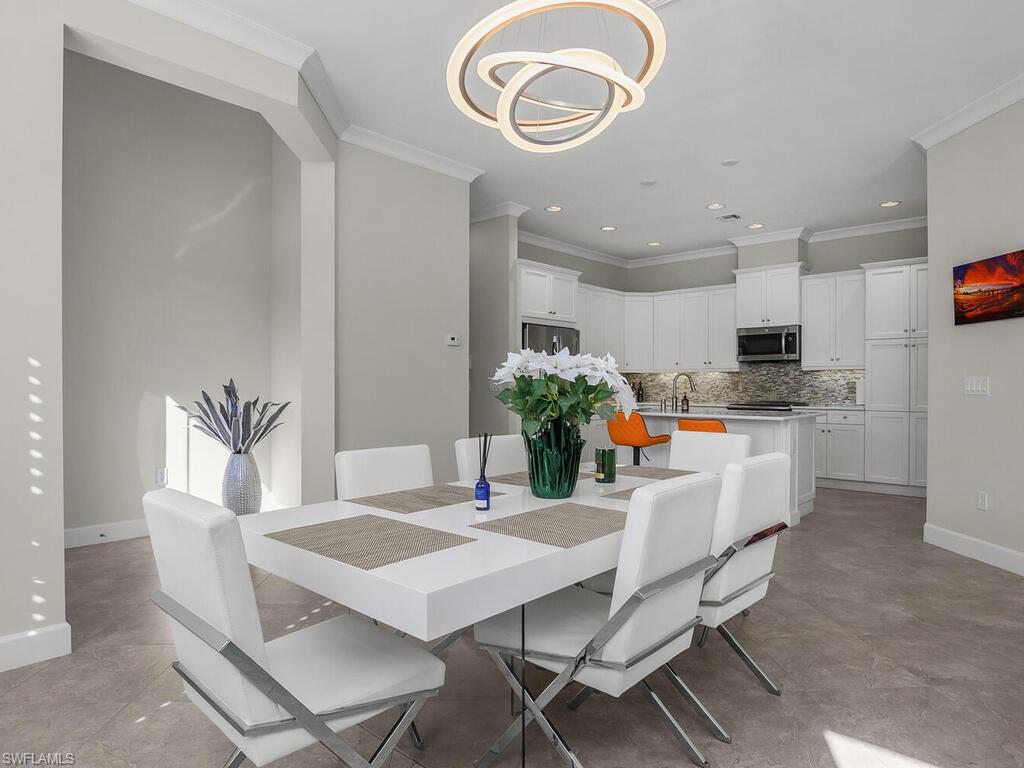 Dining area with crown molding, recessed lighting, kitchen.