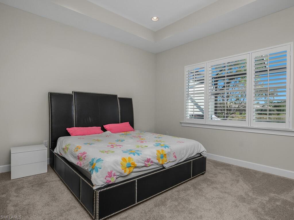 Master bedroom with a raised ceiling and recessed lighting, Plantation Shutters.