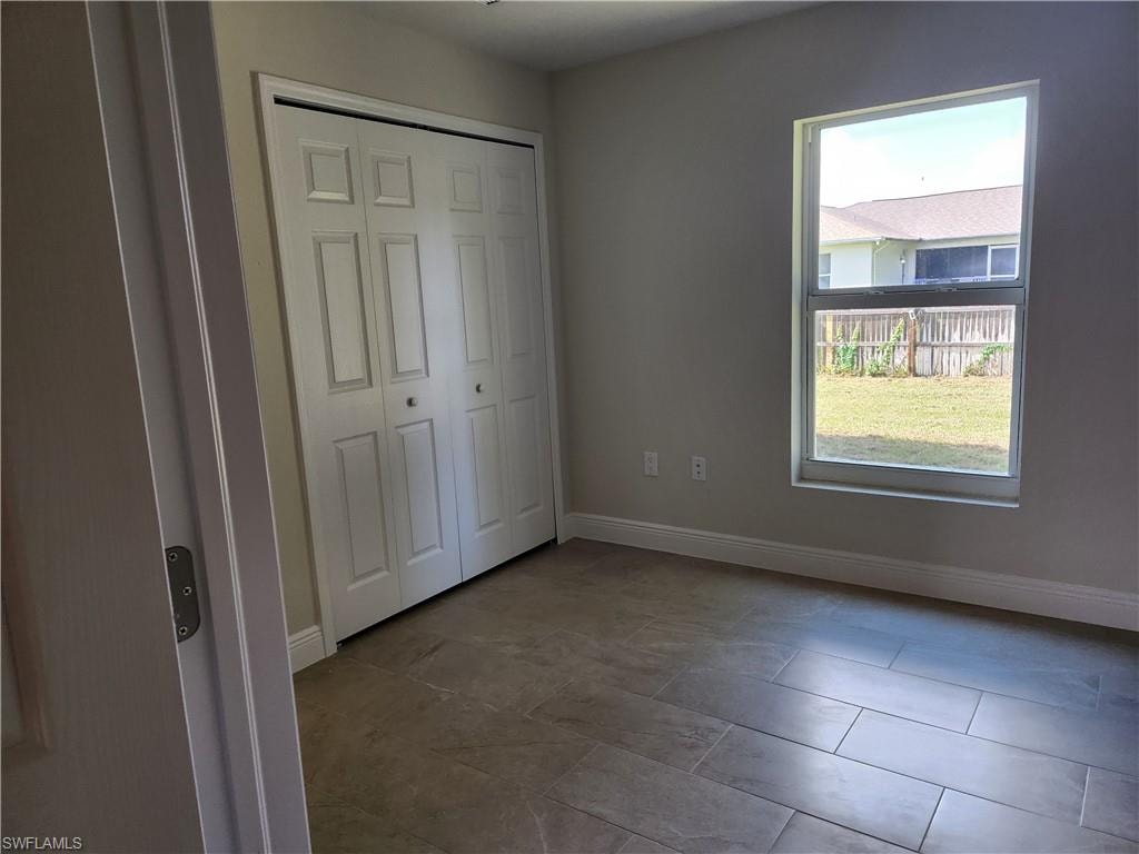 Unfurnished bedroom featuring baseboards and a closet