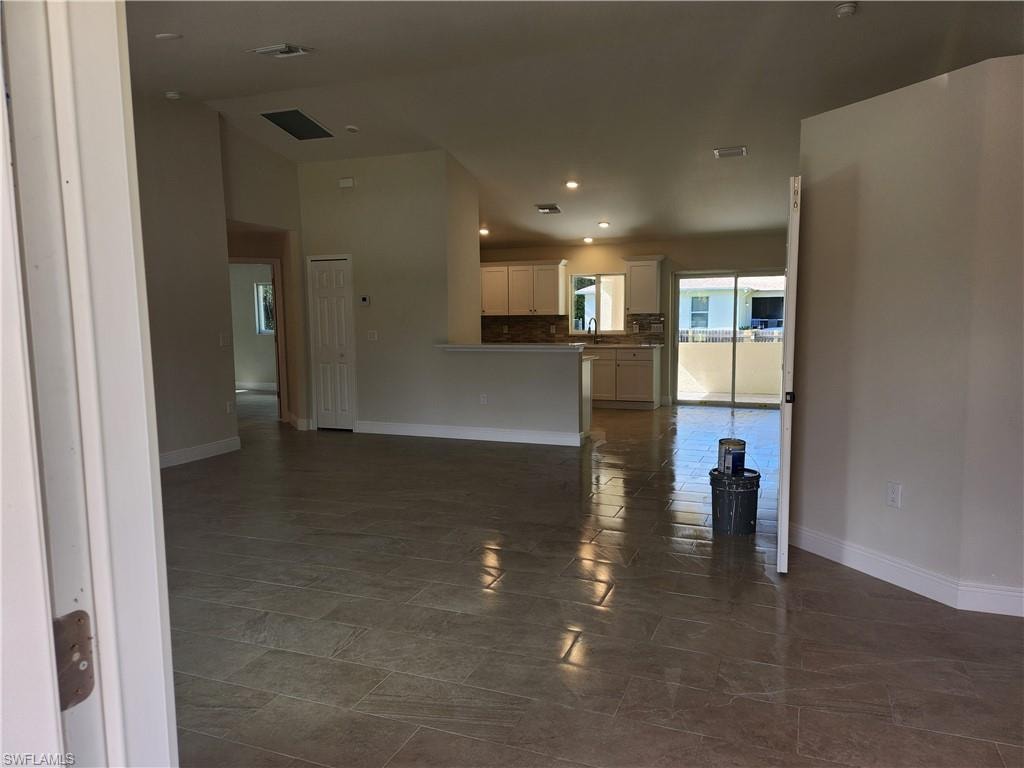 Unfurnished living room featuring baseboards and recessed lighting