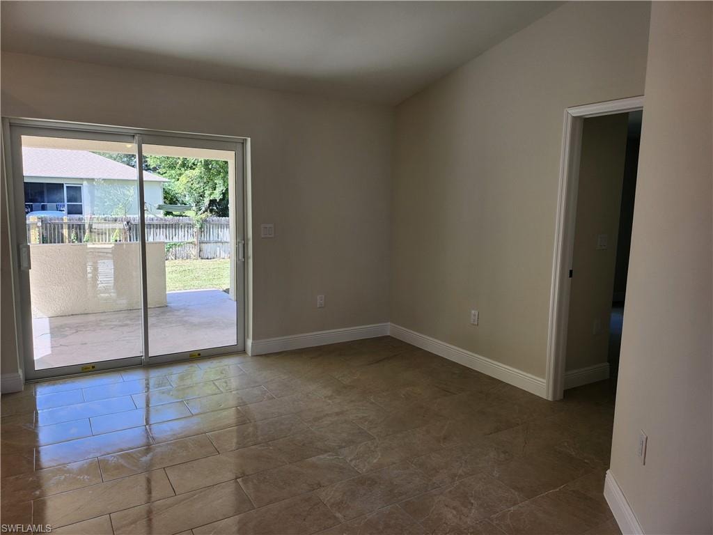 Spare room with baseboards and lofted ceiling