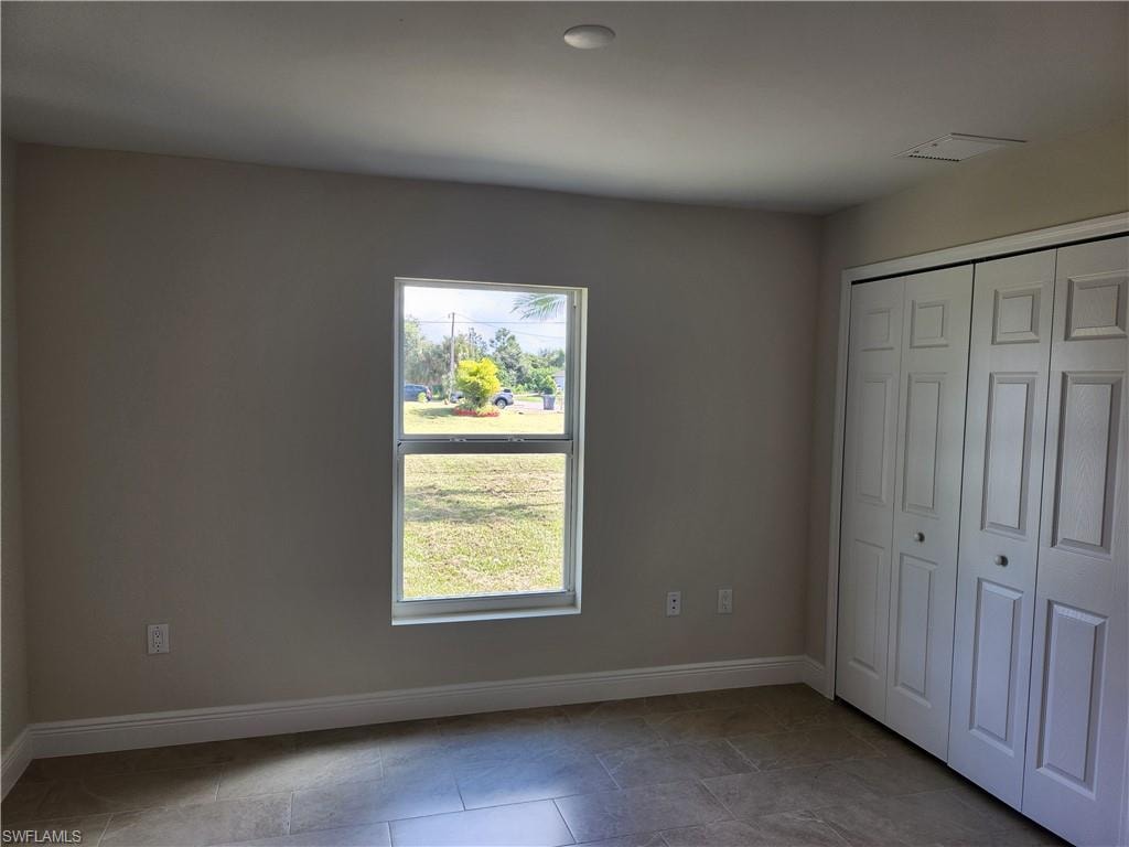 Unfurnished bedroom featuring baseboards and a closet