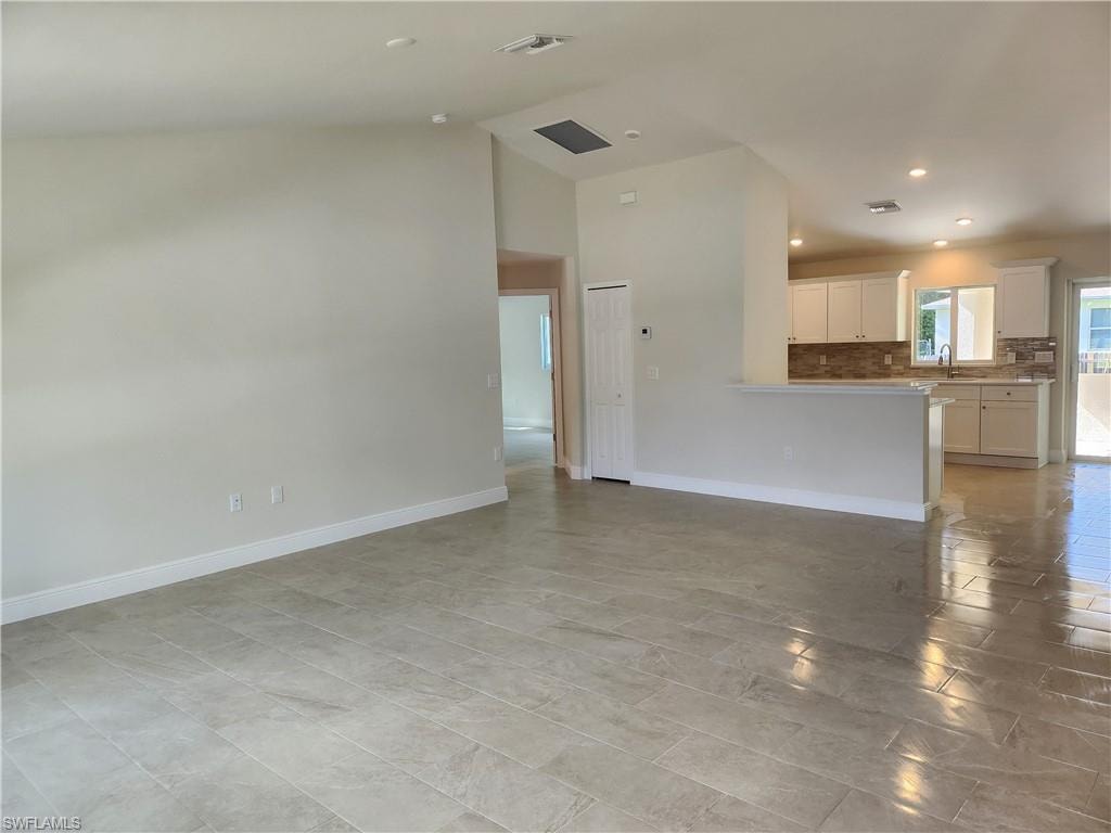 Unfurnished living room with recessed lighting and vaulted ceiling