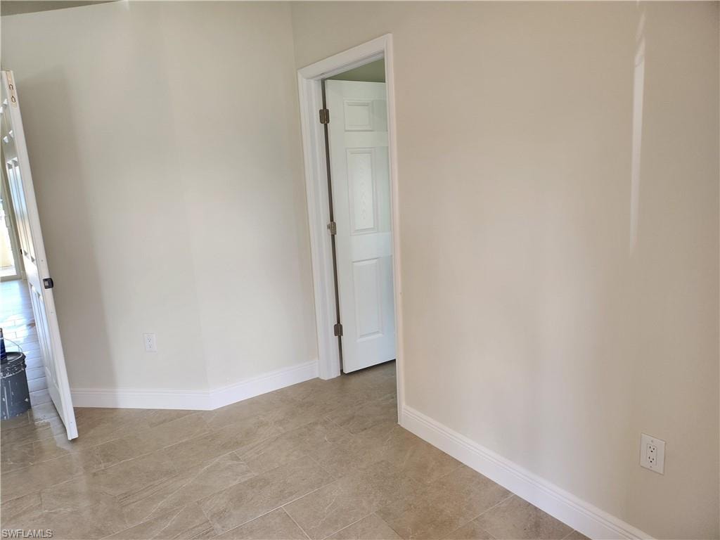 Unfurnished room featuring baseboards