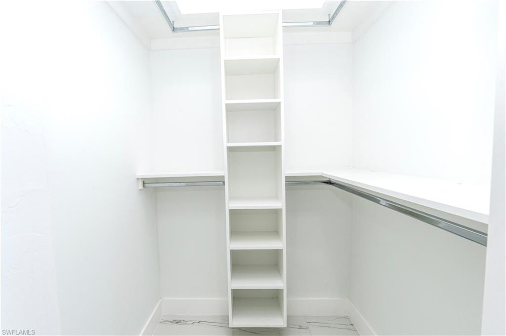 Unfurnished room featuring a raised ceiling, light marble finish floors, and recessed lighting