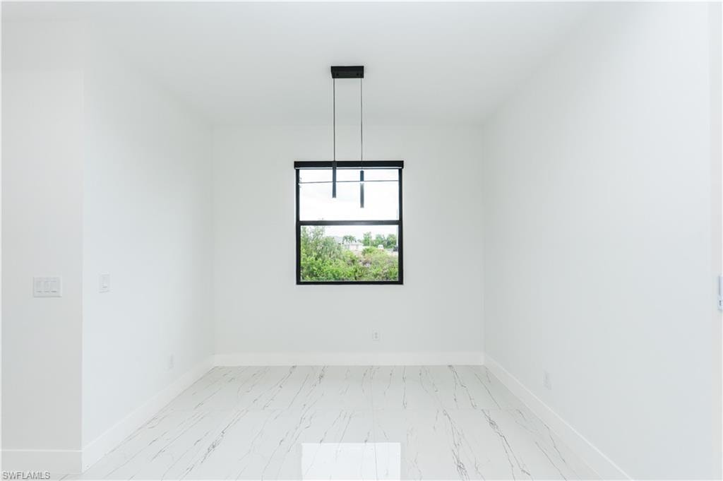 Unfurnished dining area featuring a water view and light marble finish floors