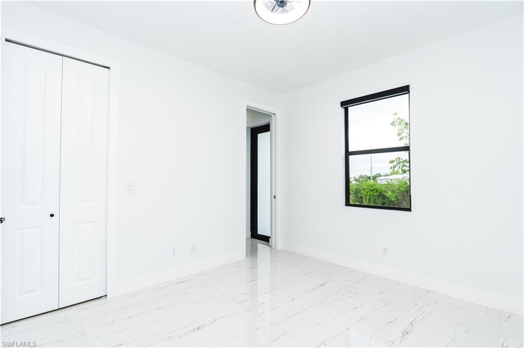 Laundry area featuring light marble finish floors, cabinet space, hookup for an electric dryer, and washer hookup