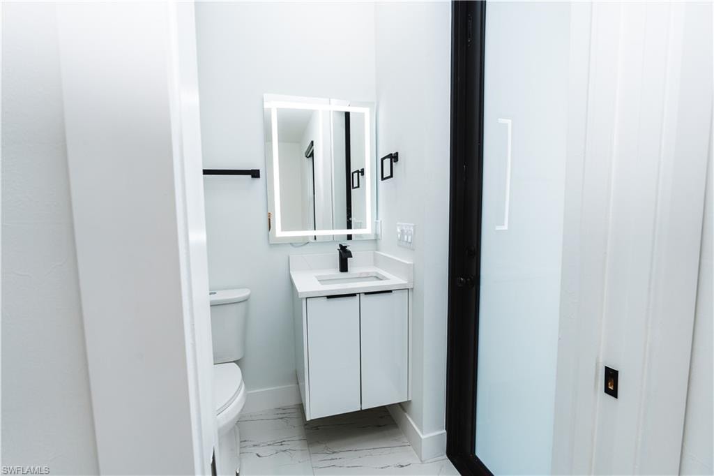 Unfurnished bedroom with light marble finish flooring, ensuite bathroom, and a closet