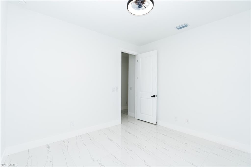 Empty room featuring baseboards and light marble finish floors